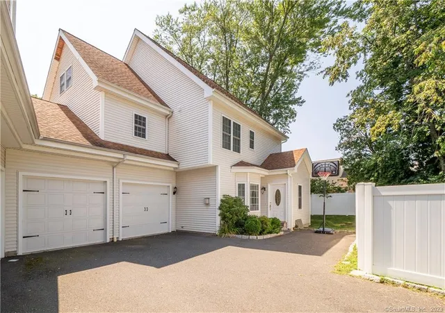 a view of a white house with a large tree