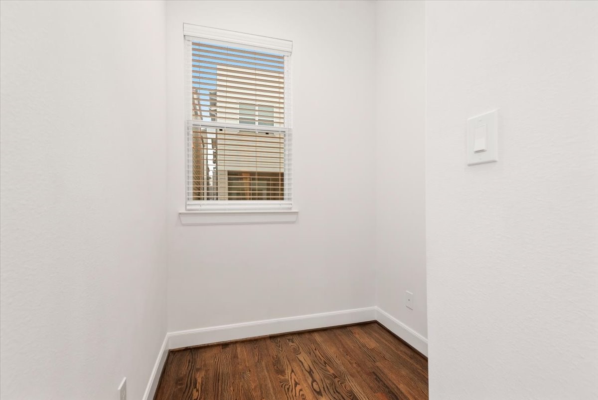 2777 Clinton Drive Houston, TX 77020 - Photo 21 of 37 Small, bright room with white walls, a window with blinds, and hardwood flooring. It's compact and could be ideal for storage or a cozy nook.