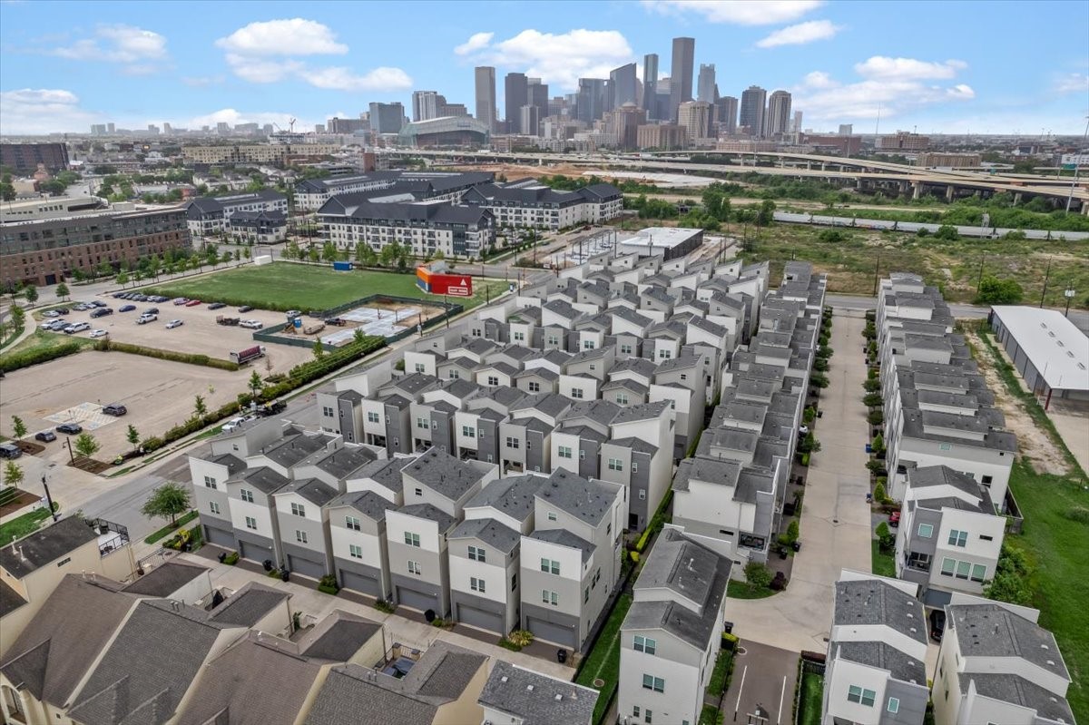 2777 Clinton Drive Houston, TX 77020 - Photo 36 of 37 Modern townhome community with a view of the city skyline. The area is well-planned with neatly arranged homes, landscaped pathways, and nearby parking. Located close to urban amenities and major roads.