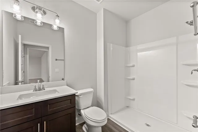 a bathroom with a sink a toilet a shower and a mirror