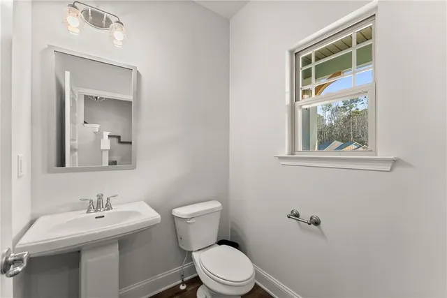 a bathroom with a toilet a sink and mirror