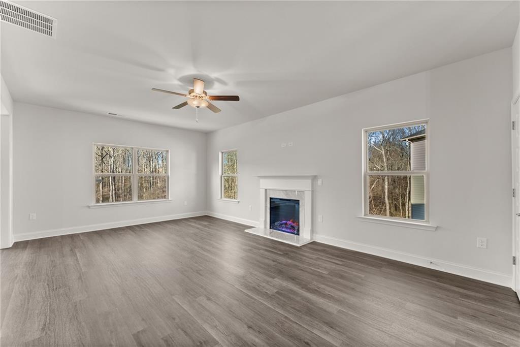 484 Magnolia Grove Place Cornelia, GA 30531 - Photo 8 of 35 a view of an empty room with wooden floor fireplace and a window