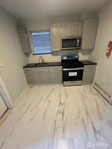 a kitchen with granite countertop a refrigerator and a stove top oven