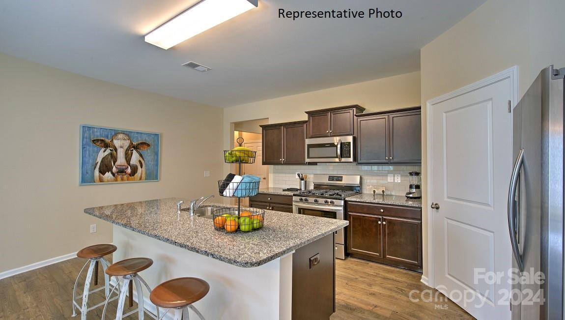 3779 Charles Street Northwest Conover, NC 28613 - Photo 15 of 36 a kitchen with a sink a stove and chairs