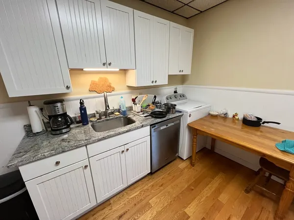 a kitchen with granite countertop a sink a stove and cabinets