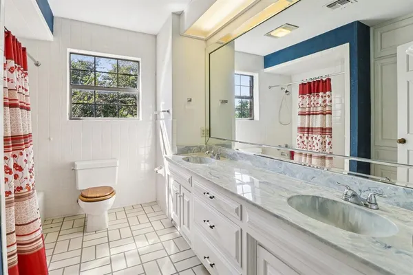 a bathroom with a toilet sink and mirror