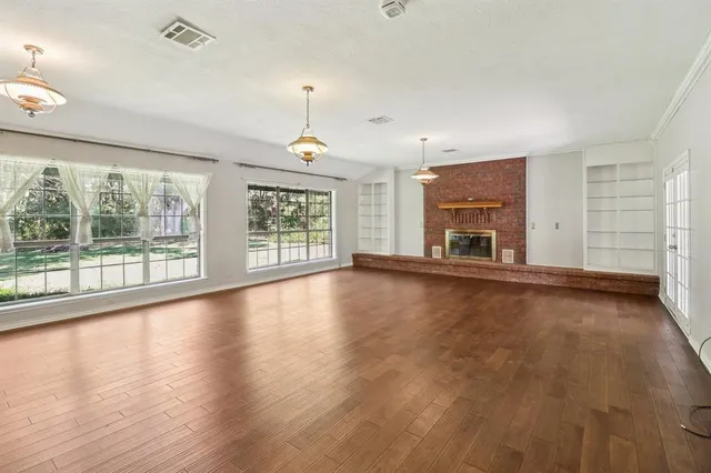 a view of empty room with wooden floor and fireplace