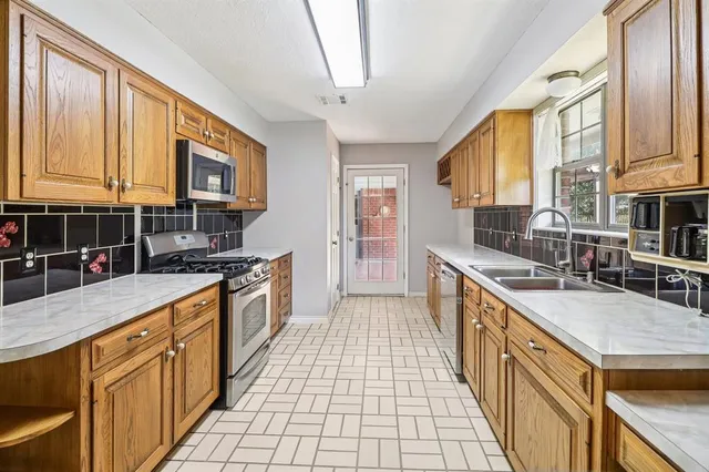 a large kitchen with stainless steel appliances granite countertop a stove a sink dishwasher a microwave oven with granite countertops and cabinets
