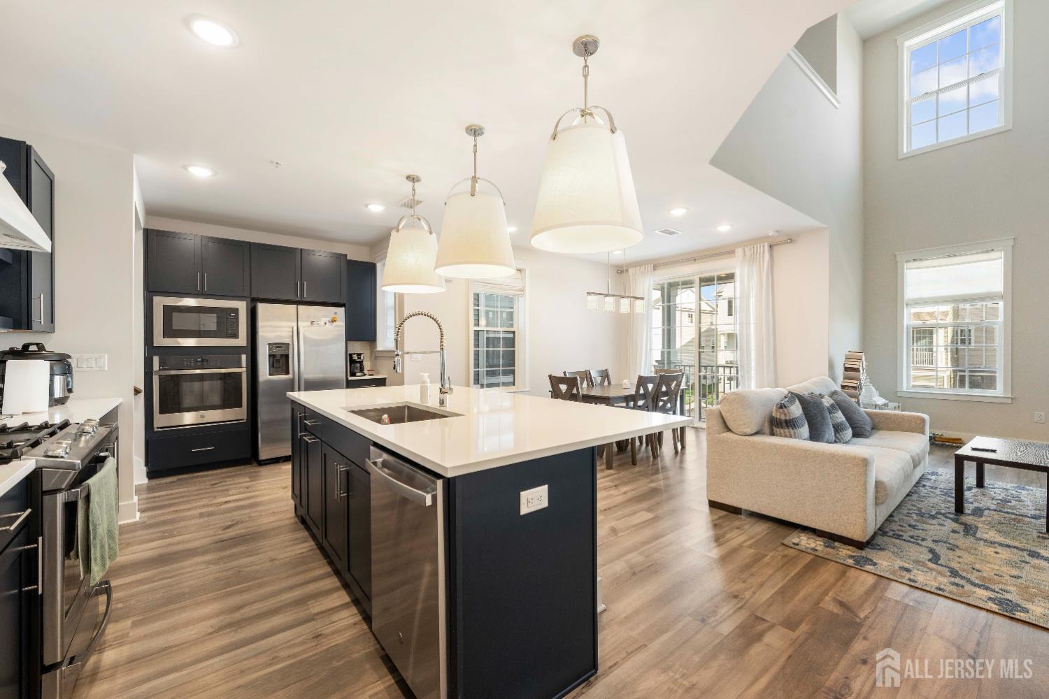 707 Station Road Dunellen, NJ 08812 - Photo 4 of 28 a hall with kitchen island a sink wooden floor and a living room view