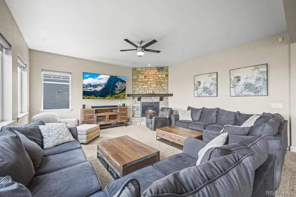 a living room with furniture ceiling fan and a flat screen tv