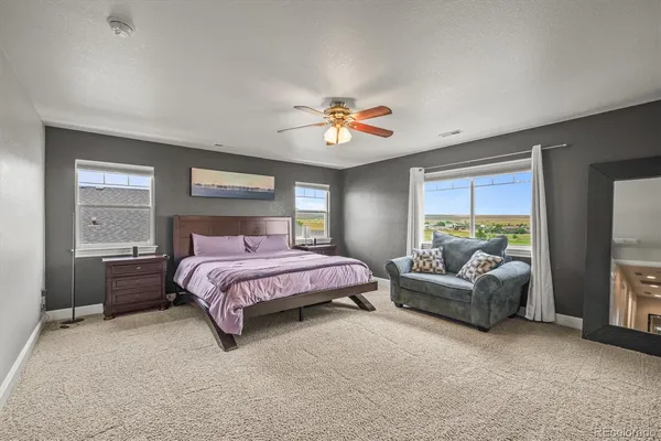 a spacious bedroom with a bed and a chandelier