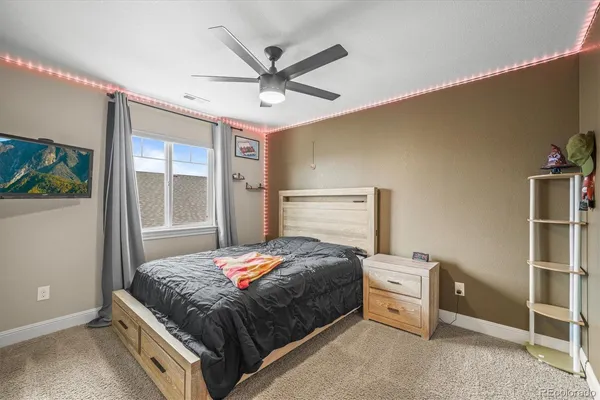 a bedroom with a bed and a ceiling fan