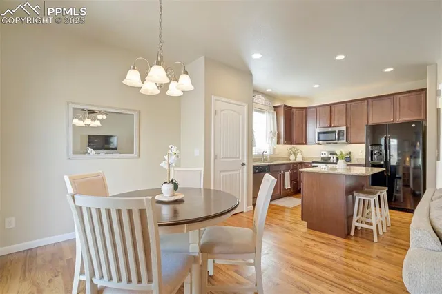 a view of a dining room with furniture a chandelier and wooden floor