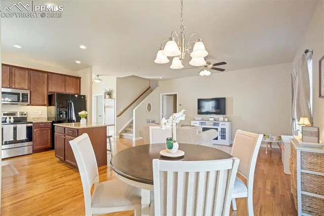 a view of a dining room with furniture a chandelier and wooden floor