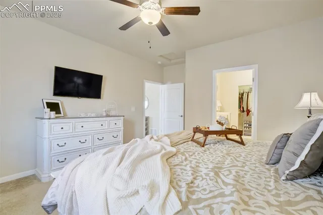 a bedroom with a bed a flat screen tv and a chandelier