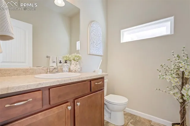 a bathroom with a granite countertop sink a toilet and a mirror