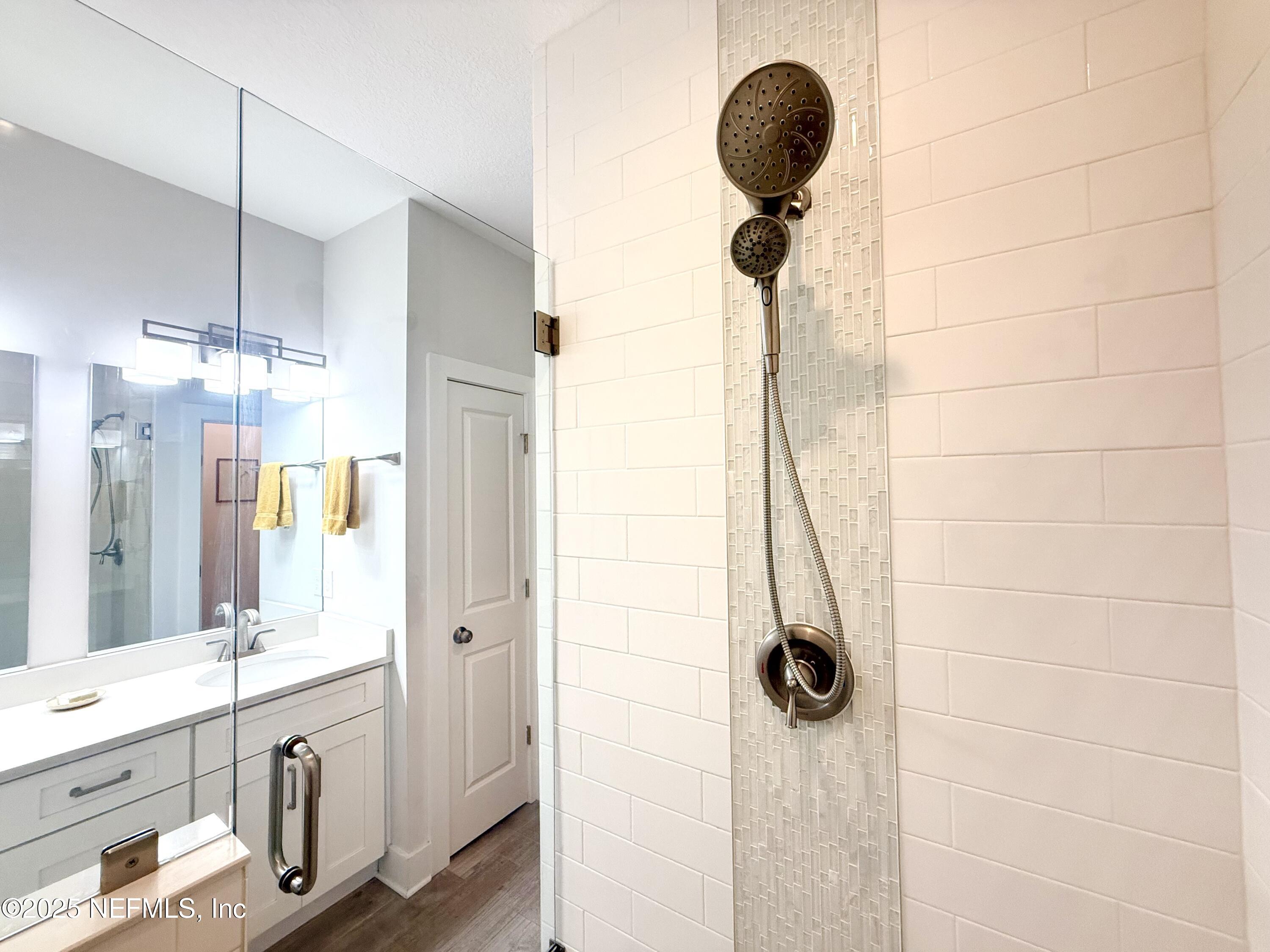 330 Trade Wind Lane St. Augustine, FL 32080 - Photo 16 of 46 a bathroom with a granite countertop shower a sink and a mirror