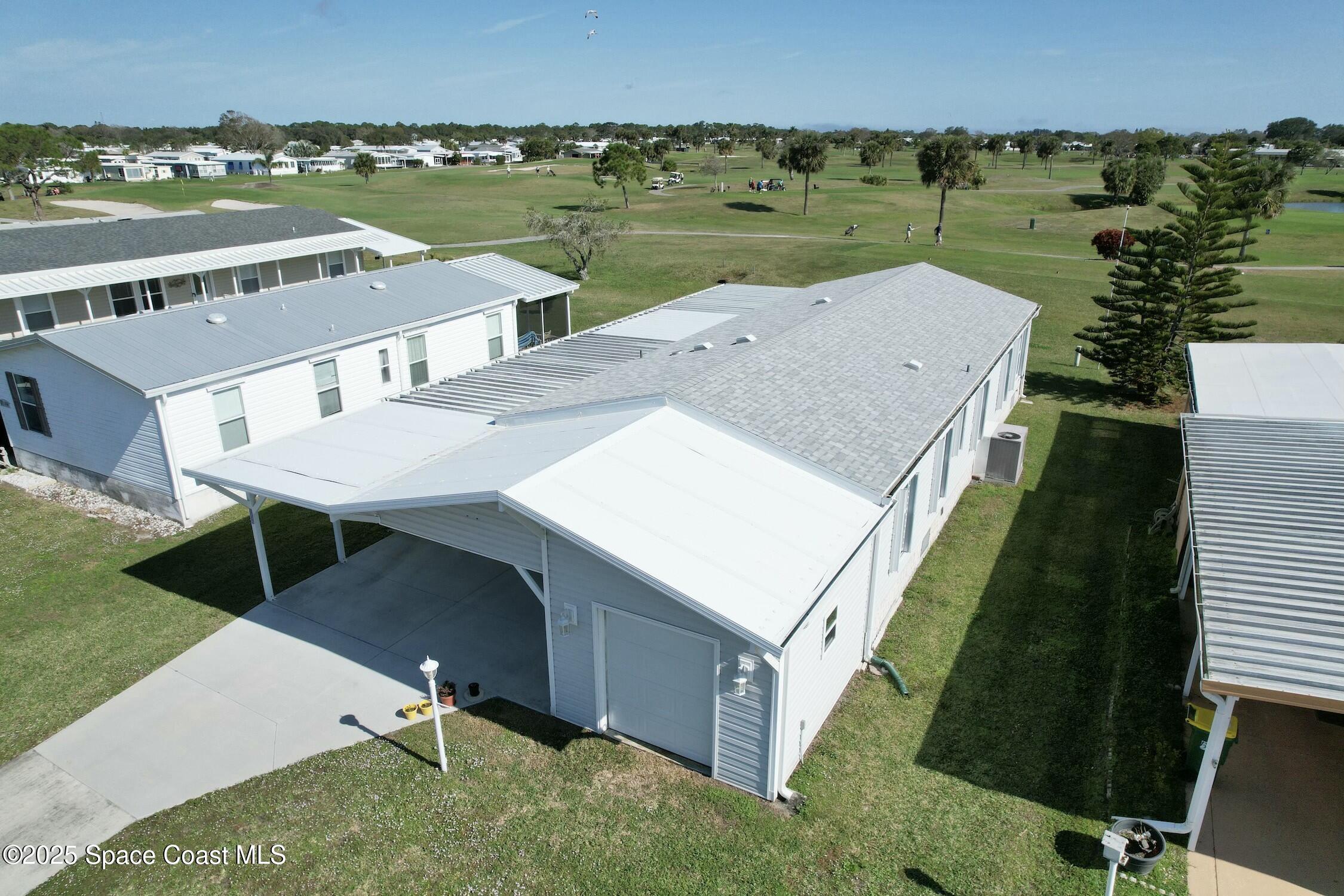 1124 Barefoot Circle Barefoot Bay, FL 32976 - Photo 11 of 79 an aerial view of a house with a garden and lake view