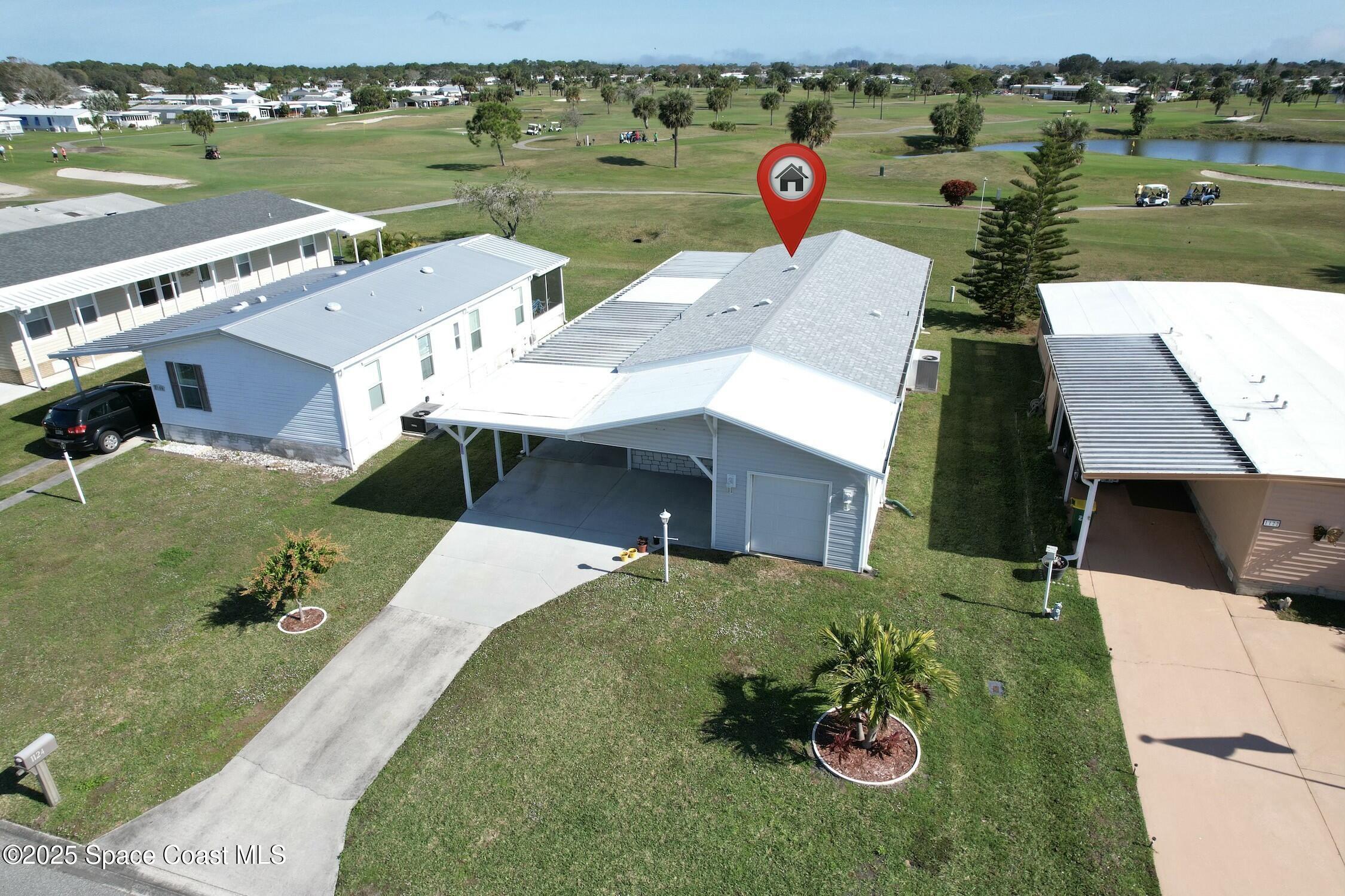 1124 Barefoot Circle Barefoot Bay, FL 32976 - Photo 2 of 79 an aerial view of a house with a garden and lake view