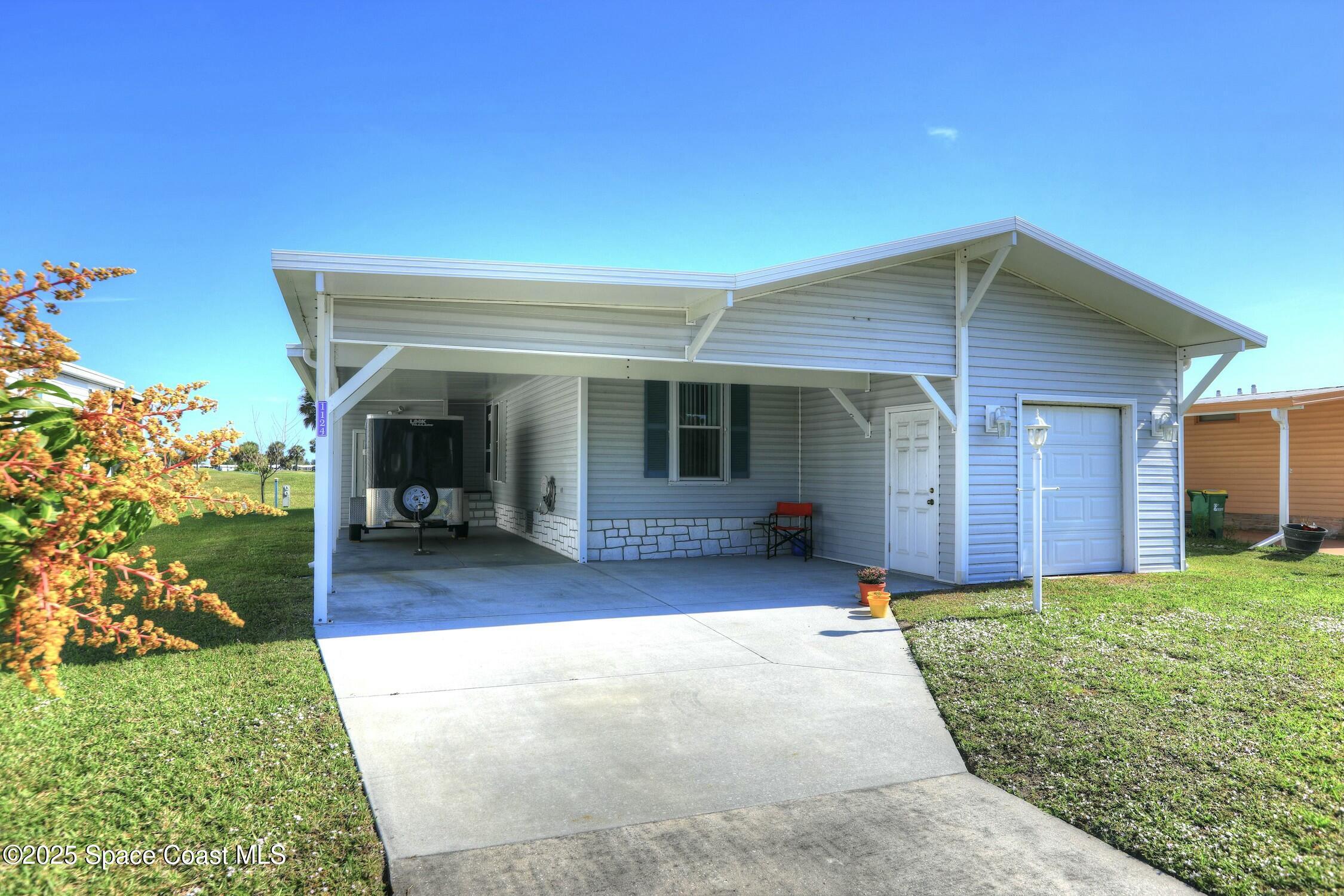 1124 Barefoot Circle Barefoot Bay, FL 32976 - Photo 21 of 79 a front view of a house with a yard and porch
