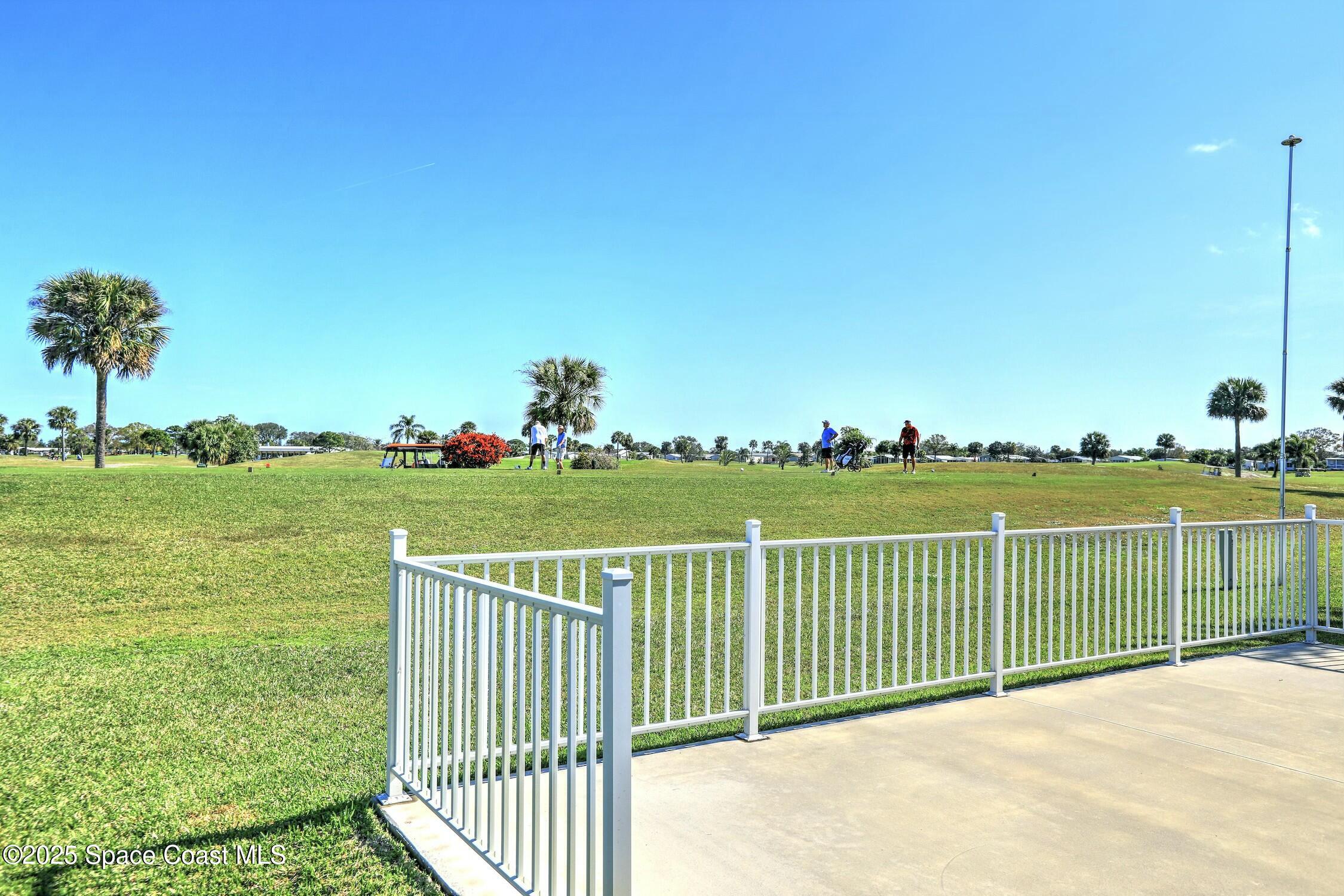 1124 Barefoot Circle Barefoot Bay, FL 32976 - Photo 25 of 79 a view of a deck with a big yard and potted plants