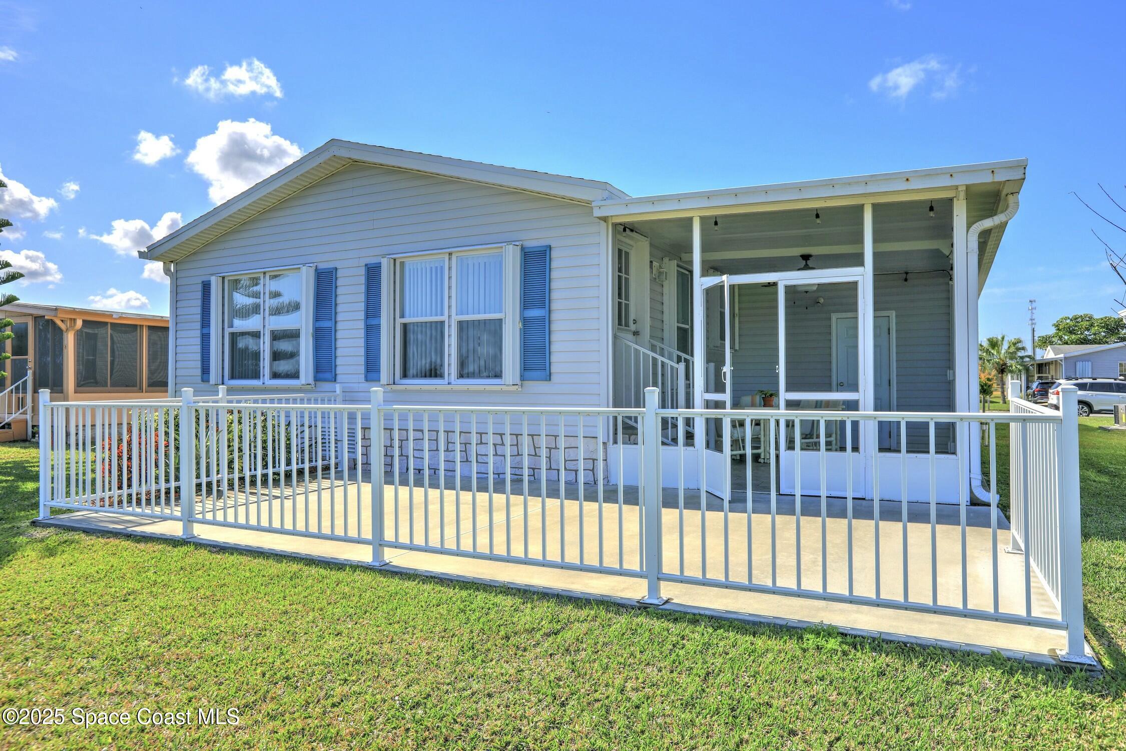 1124 Barefoot Circle Barefoot Bay, FL 32976 - Photo 26 of 79 a view of a house with a small yard and wooden fence