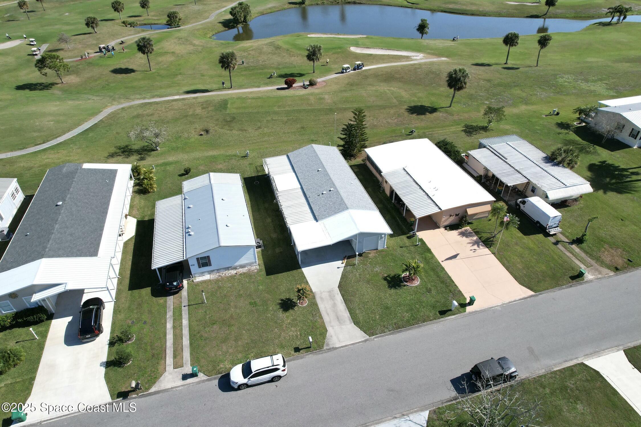 1124 Barefoot Circle Barefoot Bay, FL 32976 - Photo 3 of 79 an aerial view of a house with a garden and parking spaces