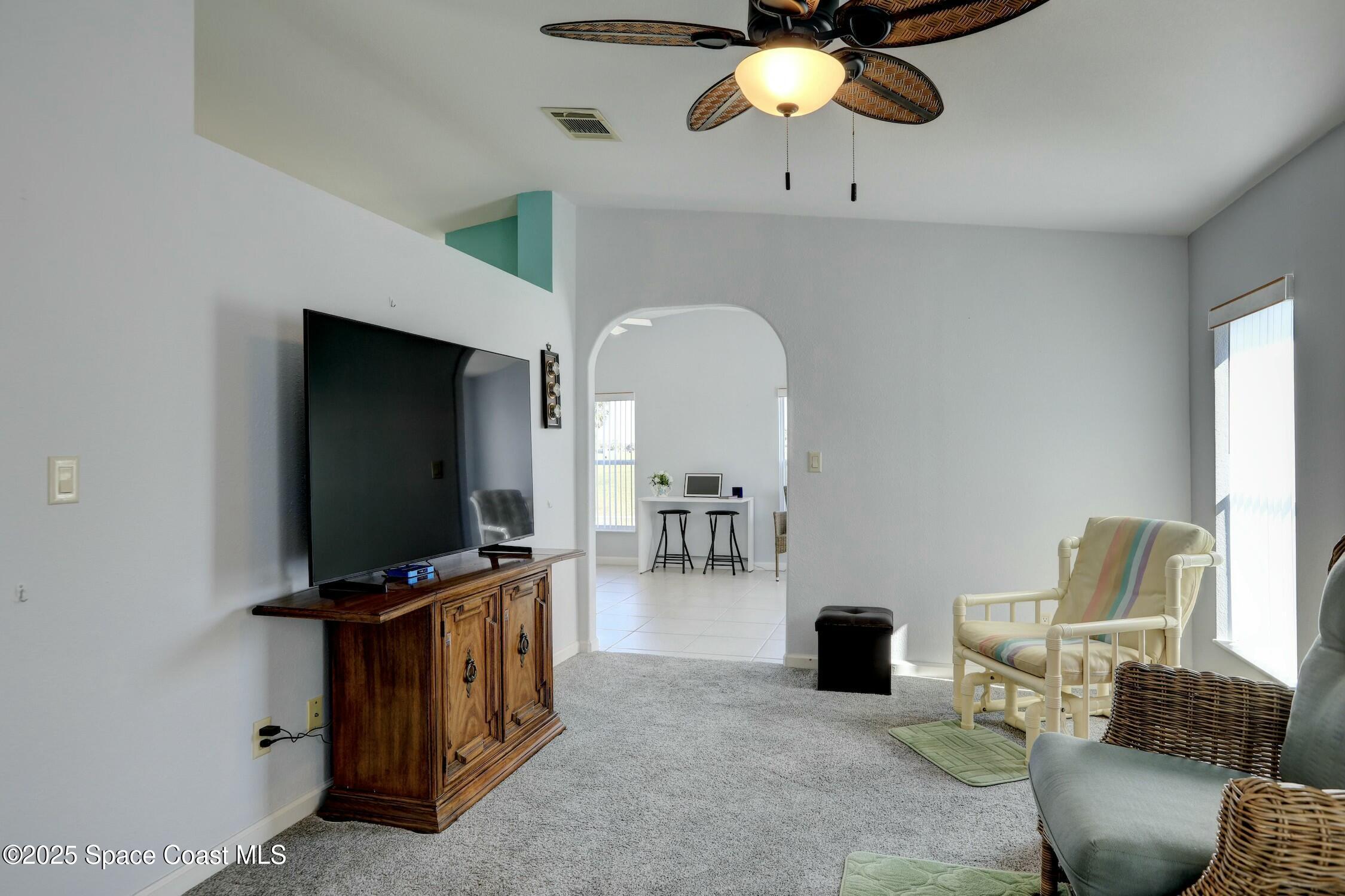 1124 Barefoot Circle Barefoot Bay, FL 32976 - Photo 33 of 79 a living room with furniture and a flat screen tv