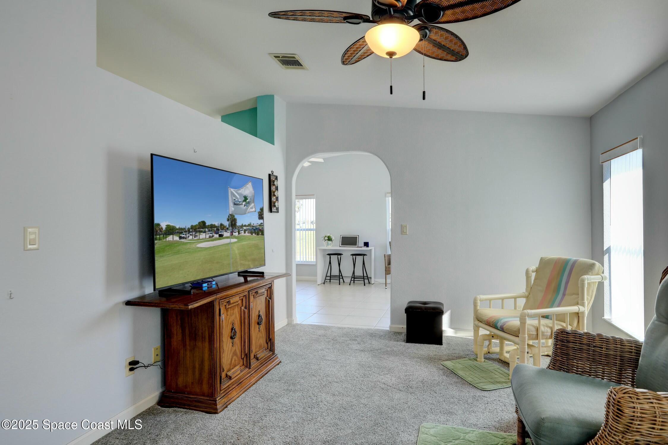 1124 Barefoot Circle Barefoot Bay, FL 32976 - Photo 34 of 79 a living room with furniture and a flat screen tv