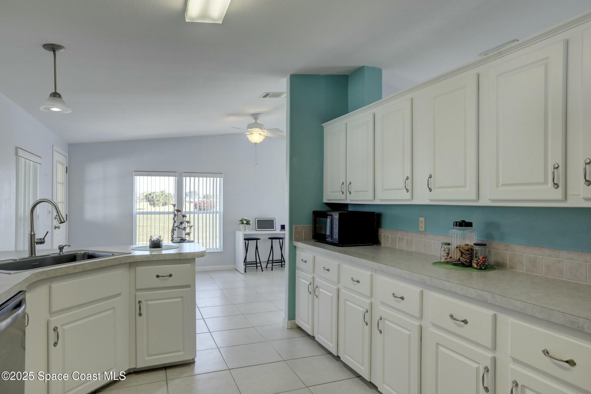 1124 Barefoot Circle Barefoot Bay, FL 32976 - Photo 49 of 79 a kitchen with white cabinets and sink