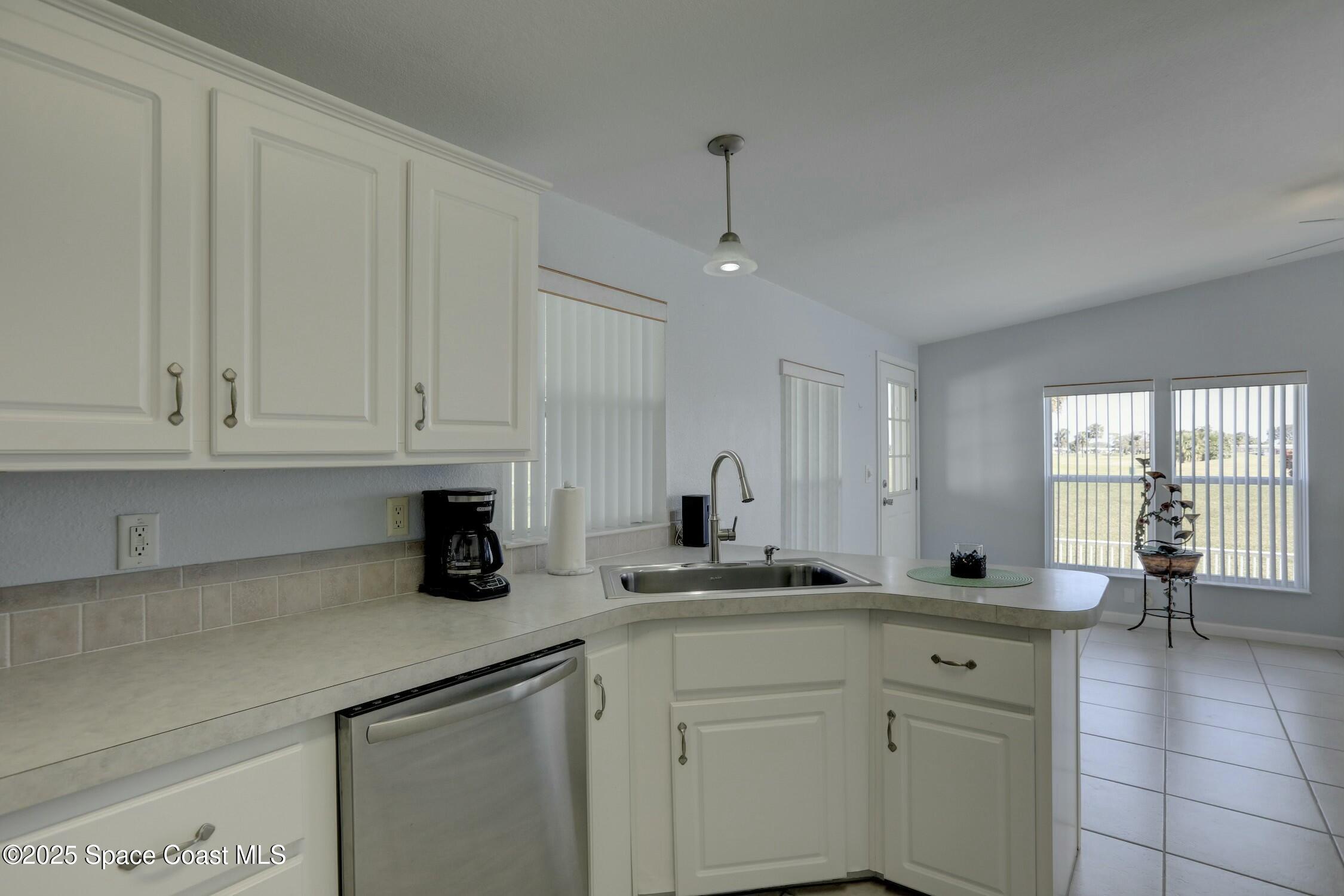 1124 Barefoot Circle Barefoot Bay, FL 32976 - Photo 50 of 79 a kitchen with white cabinets and sink