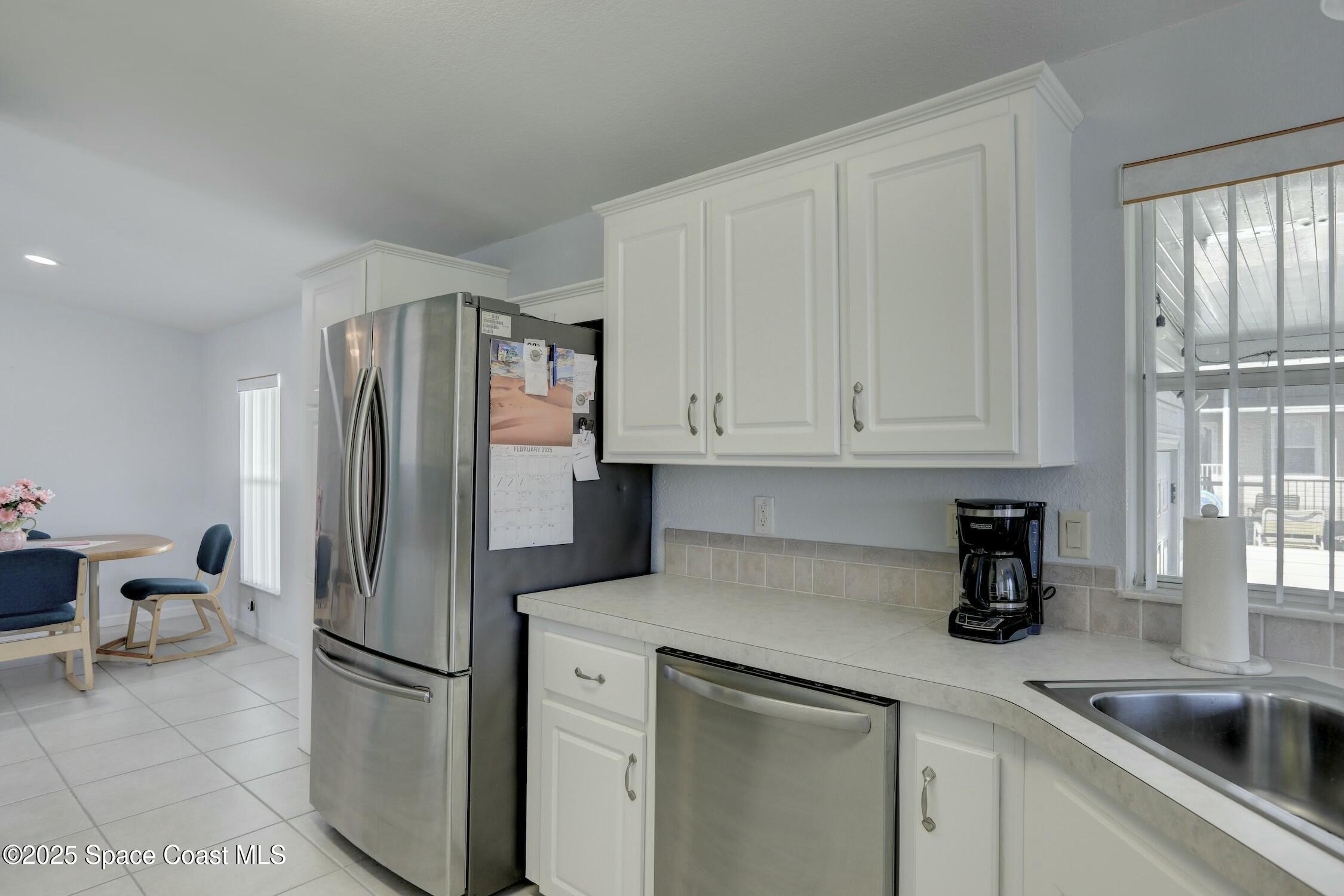 1124 Barefoot Circle Barefoot Bay, FL 32976 - Photo 54 of 79 a kitchen with stainless steel appliances granite countertop a refrigerator sink and cabinets