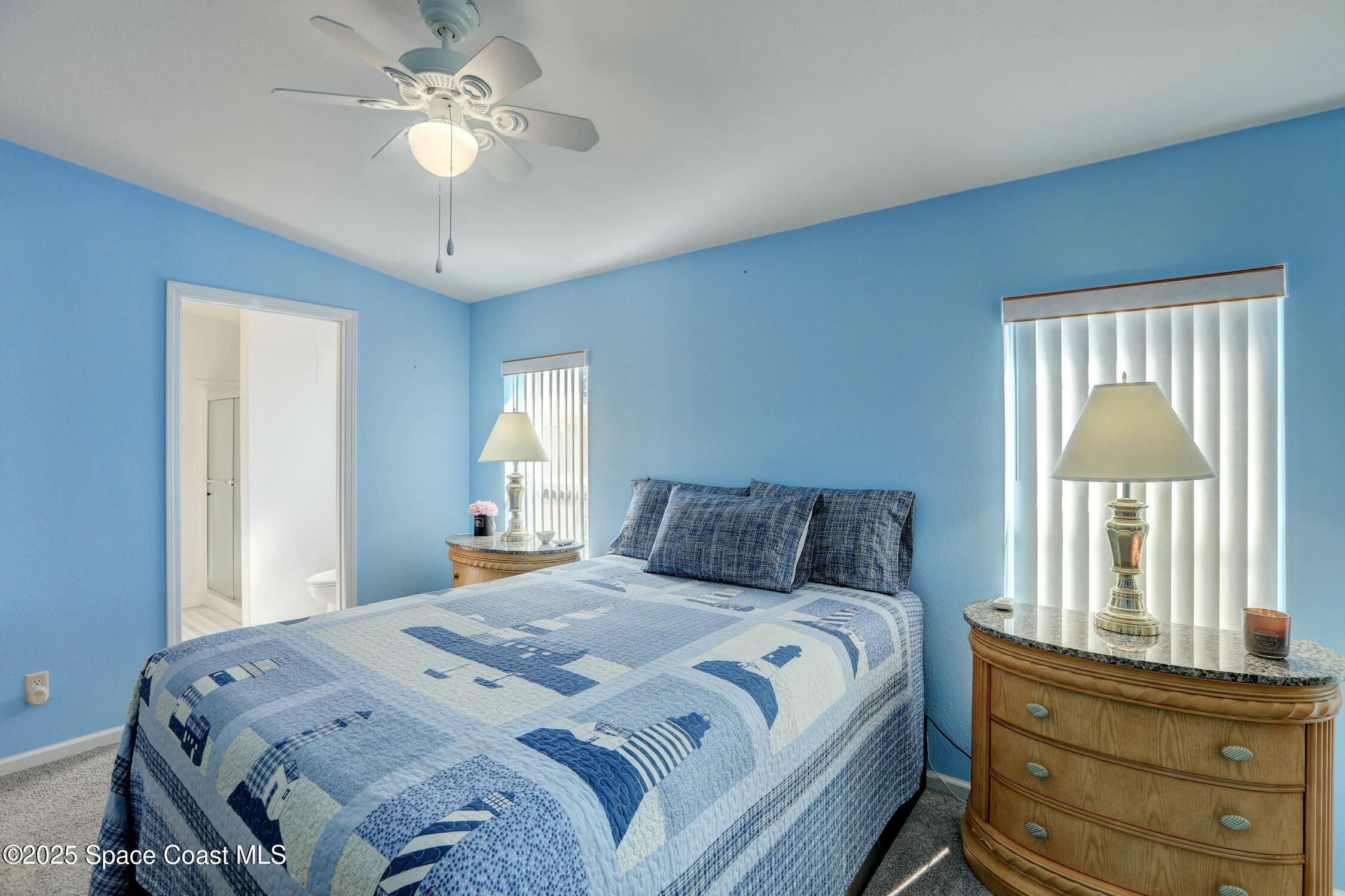 1124 Barefoot Circle Barefoot Bay, FL 32976 - Photo 56 of 79 a bedroom with a large bed and a chandelier
