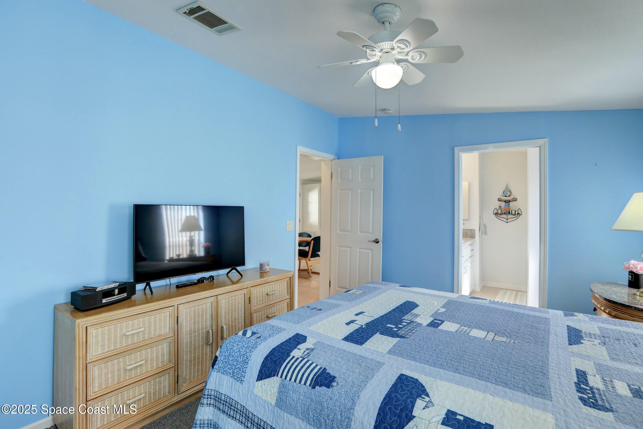 1124 Barefoot Circle Barefoot Bay, FL 32976 - Photo 57 of 79 a bedroom with a bed and a flat tv screen on dresser