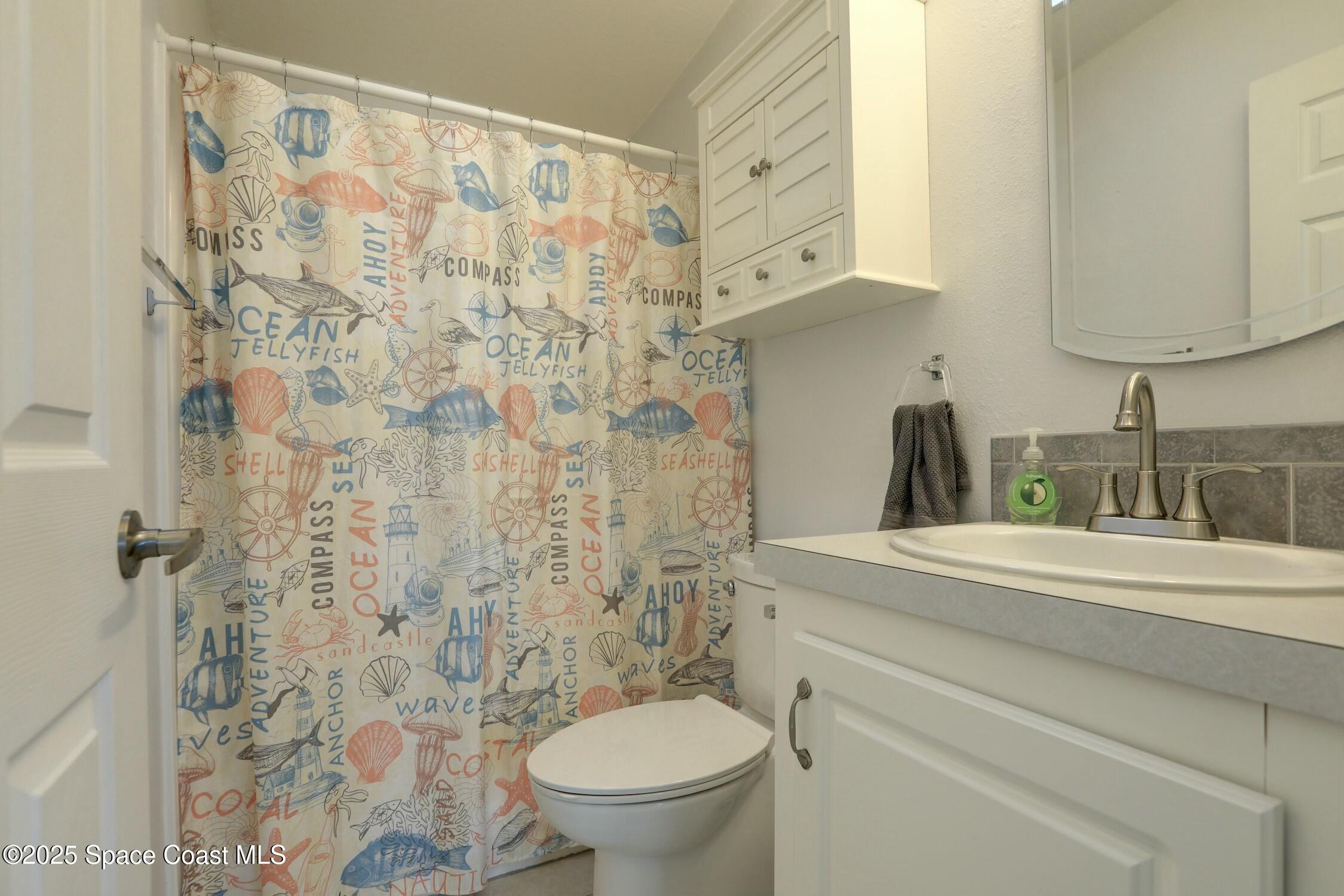 1124 Barefoot Circle Barefoot Bay, FL 32976 - Photo 61 of 79 a bathroom with a sink a toilet and a mirror