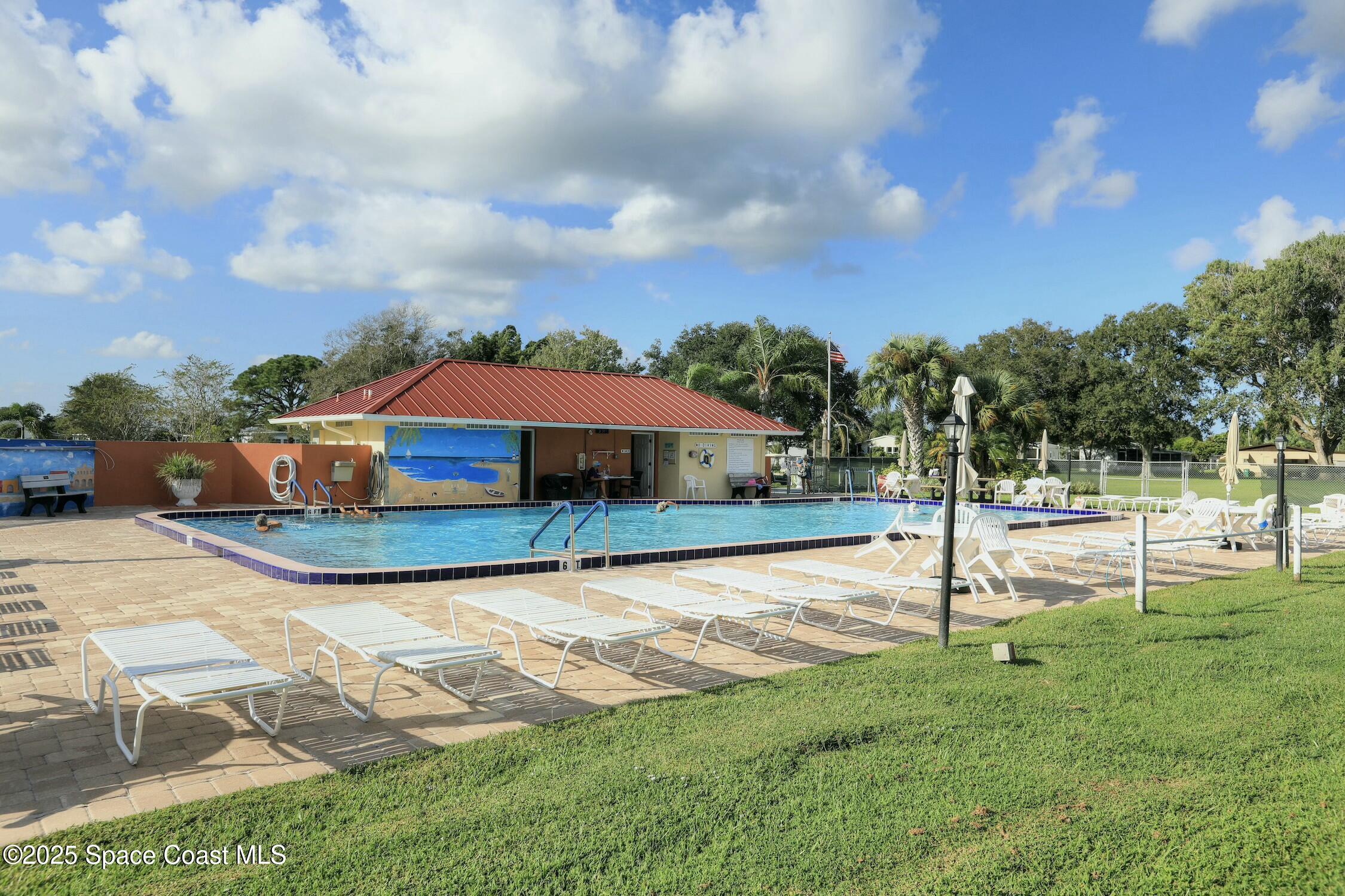 1124 Barefoot Circle Barefoot Bay, FL 32976 - Photo 70 of 79 a view of a house with swimming pool and sitting area