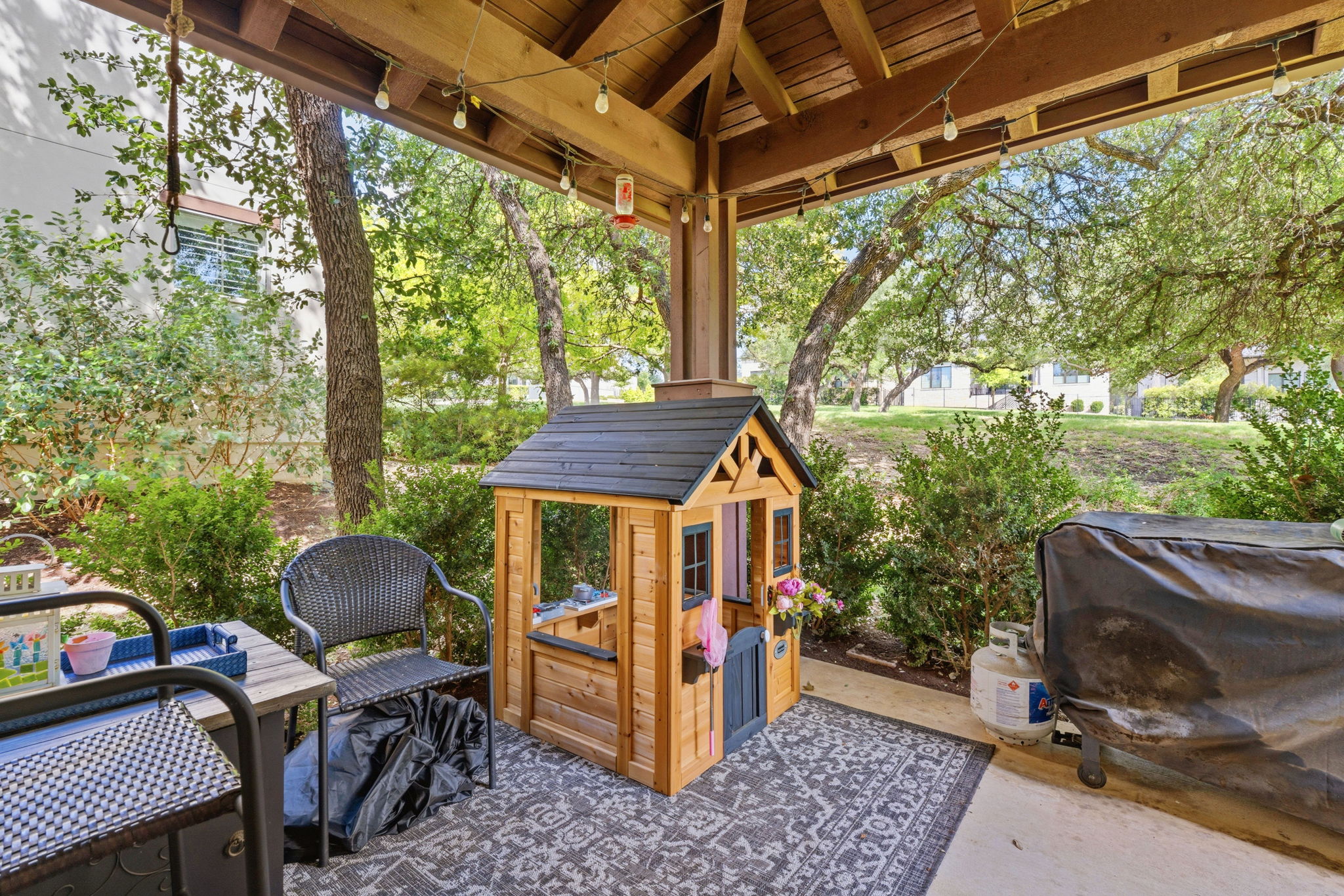 15317 Falconhead Grove Loop Austin, TX 78738 - Photo 25 of 36 Covered patio featuring a wood-finish ceiling, exposed beams, and string lighting