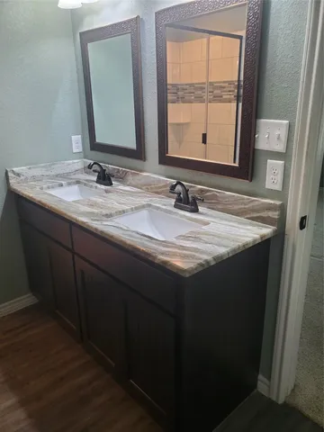a bathroom with a granite countertop sink a mirror and a window