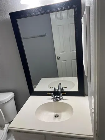 a bathroom with a sink and mirror with toilet