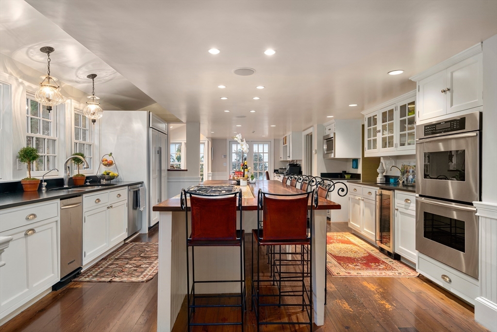 883 High Street Dedham, MA 02026 - Photo 11 of 42 a large kitchen with cabinets chairs and stainless steel appliances