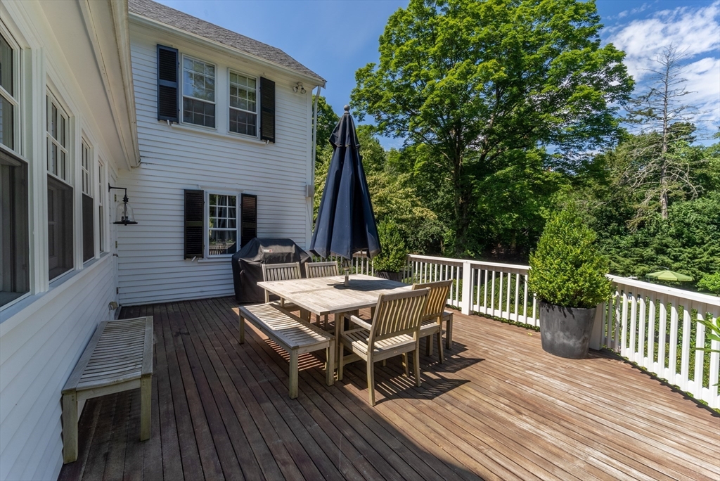 883 High Street Dedham, MA 02026 - Photo 14 of 42 a view of a roof deck with table and chairs and wooden floor