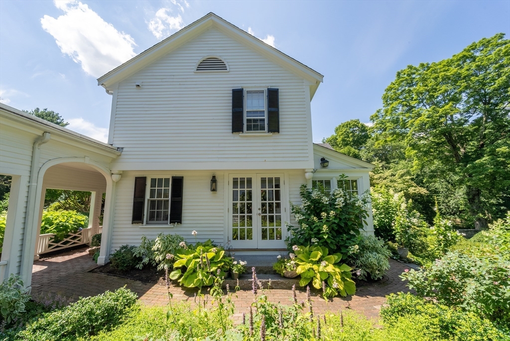 883 High Street Dedham, MA 02026 - Photo 23 of 42 a house with a lot of flower plants in front of house