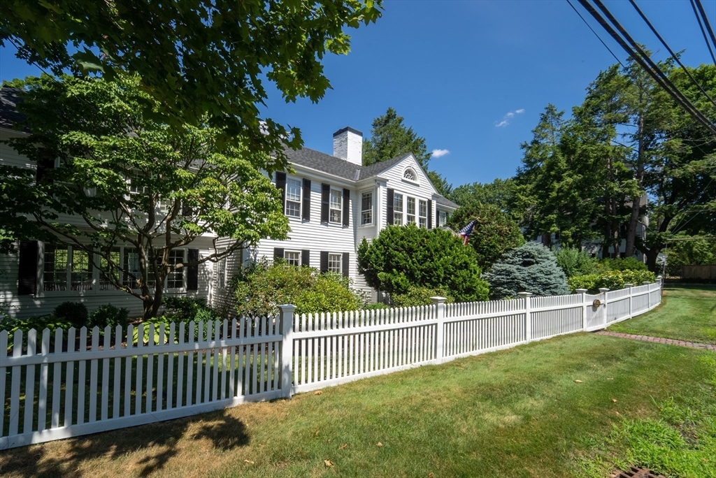 883 High Street Dedham, MA 02026 - Photo 33 of 42 a view of a house with a small yard and a fence