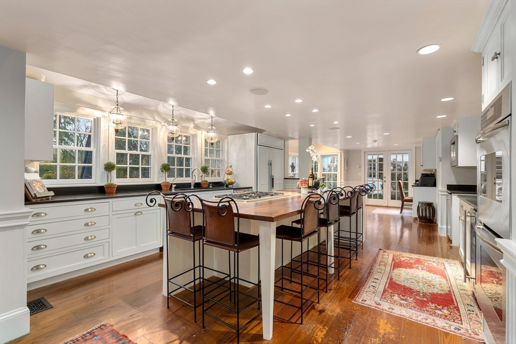 883 High Street Dedham, MA 02026 - Photo 7 of 42 a view of a kitchen with kitchen island stainless steel appliances refrigerator stove dining table and chairs