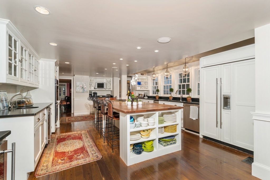 883 High Street Dedham, MA 02026 - Photo 10 of 42 a large white kitchen with stainless steel appliances granite countertop a stove and a refrigerator