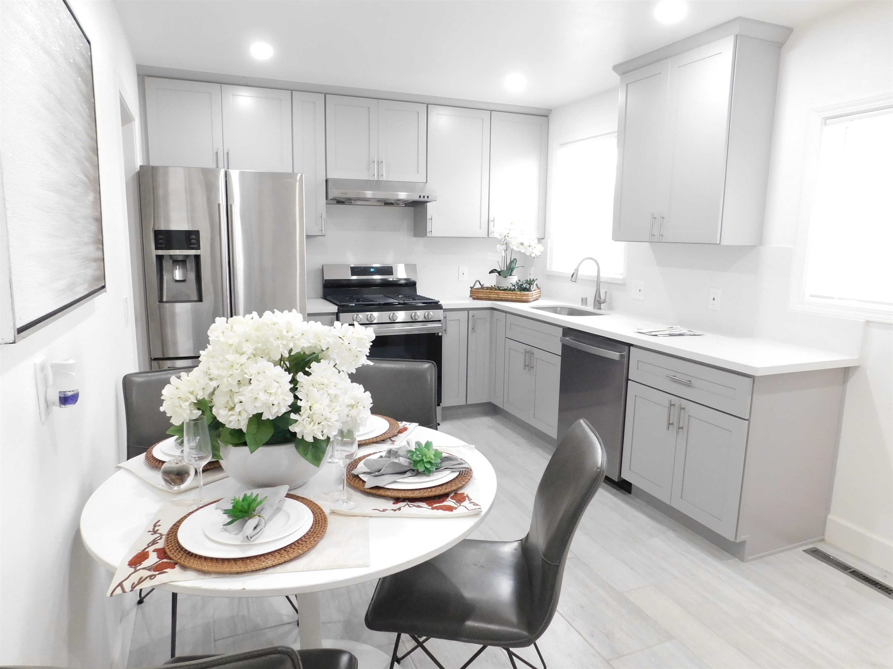 15018 Edgemoor Street San Leandro, CA 94579 - Photo 7 of 13 a kitchen with stainless steel appliances kitchen island granite countertop a sink a stove a dining table and chairs