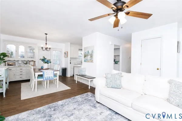 a living room with furniture a dining table and a chandelier