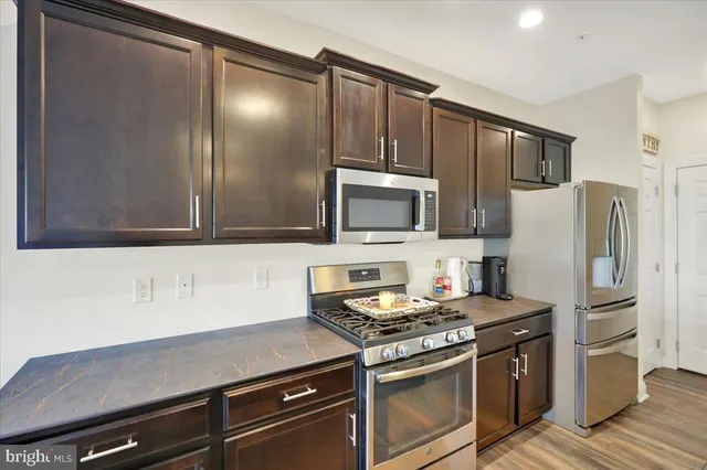 a kitchen with stainless steel appliances a refrigerator stove and microwave