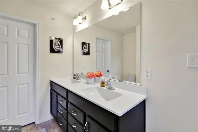 a bathroom with a sink vanity and a mirror