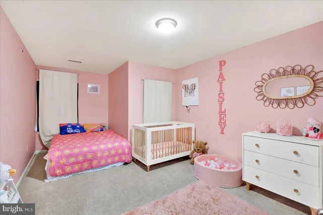 a bedroom with pink bed and dresser
